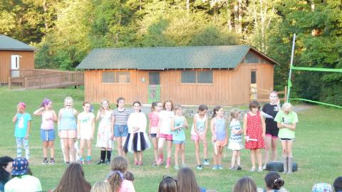 Group of campers in a line on the lawn.