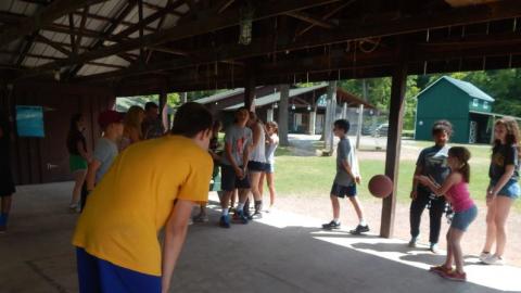 Youth playing four-square in the pavilion. 