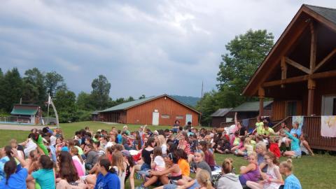 Campers seated in large group on lawn in front of Director's House.