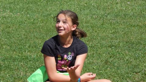 Youth sitting on ground laughing.