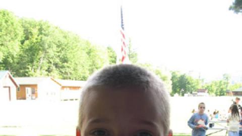 Smiling camper wearing their name tag after check-in.