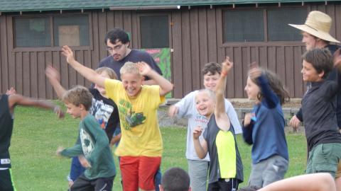 Cabin group smiling and waving arms in the air.