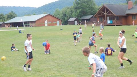 Campers scattered around the field playing dodgeball.