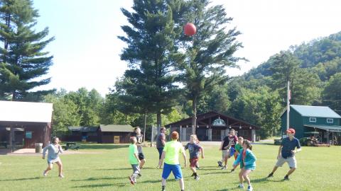 Group of youth in a circle with a ball in the air above them.