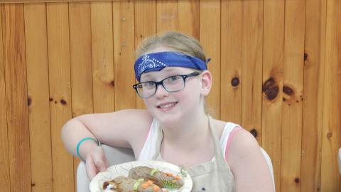 Youth holding up a culinary creation.