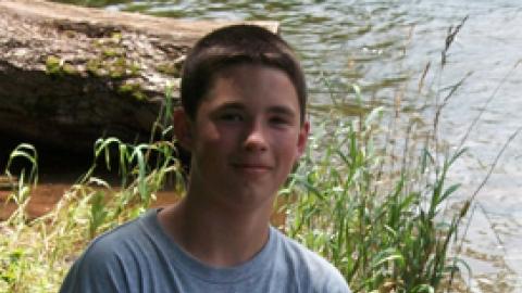 youth holding a small fish.