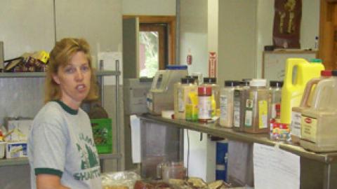 Assistant cook unpacks rolls in the camp kitchen.