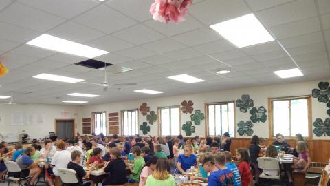 Campers and counselors seated together for a family style meal.