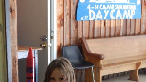 Youth sits at table with model rocket that looks like a crayon.