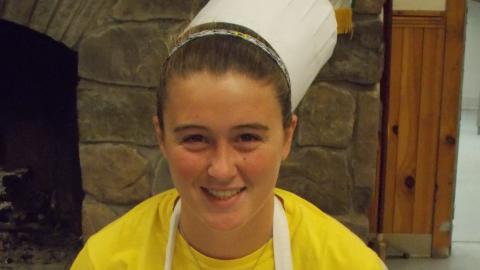 camper holding culinary creation wearing chef's hat
