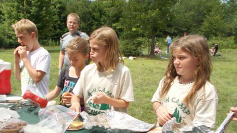 campers making food outside on lawn