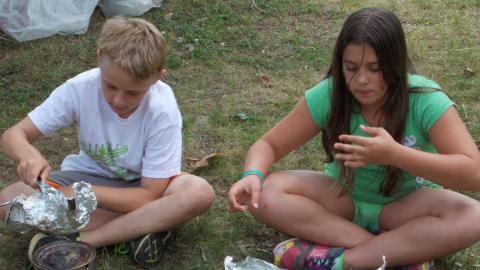 campers cooking outdoors using coffee cans