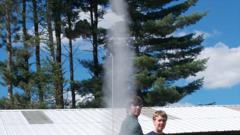 campers watching model rockets launching 