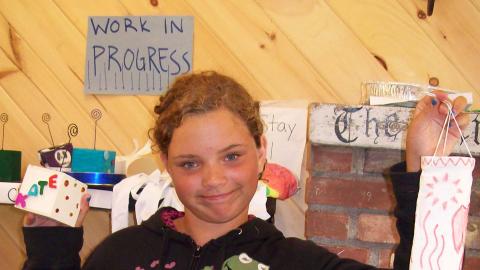 camper holding arts and craft projects - a hanging lantern and a box 