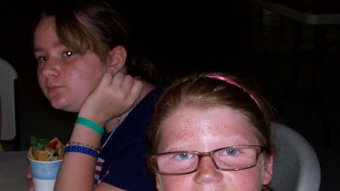 youth enjoy parfaits they have made. One camper presents hers to the camera.