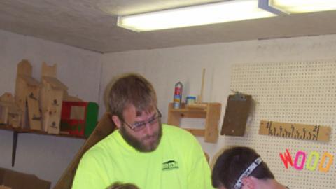 Youth working on a wood project with the help of an adult. 