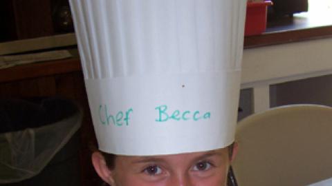 chef Becca holding a plate of baked potatoes with added veggies to look like mice.