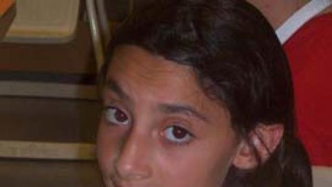 youth holding parfait in apron.