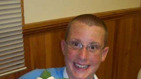 youth looking at camera and holding parfait they made.