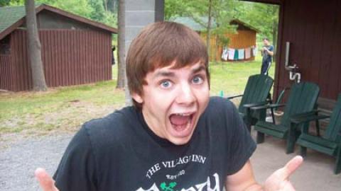 Smiling youth puts his thumbs up. 