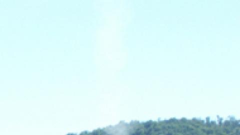 staff looking up into the sky with a trail of smoke from recently launched rocket in front of them.