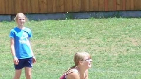 Youth crouching down with a volleyball.