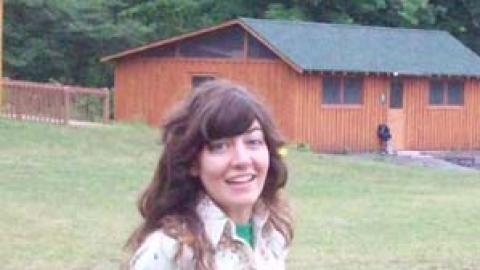 staff member in field looking at camera with confused face.