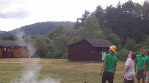 Campers watch model rockets launch. 