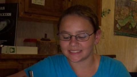 youth holding tweezers and beginning to dissect an owl pellet.