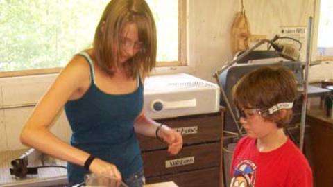 Staff assists youth at chop saw.