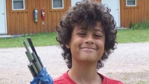 Camper smiling and holding bag of tent poles.