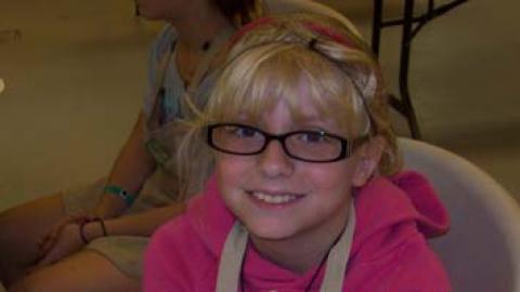 Smiling youth holding a culinary creation.