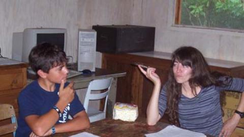 Class counselor works one-on-one with a counselor in training participant in a Science Center pod.
