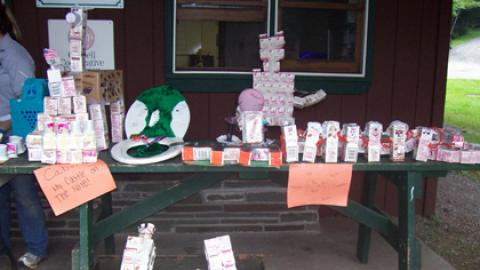 variety of milk carton creations on the dining hall porch including human-like figure, tower, giraffe, misc.