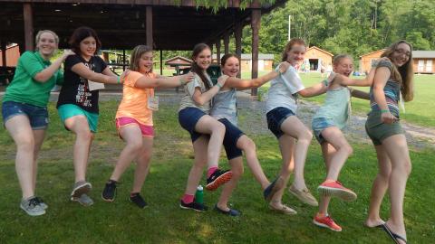 Campers in line doing sideways kicks. 