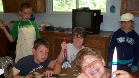Smiling youth holds up a model rocket. 