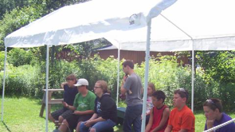 Youth sitting on a bench during a shooting sports class. 