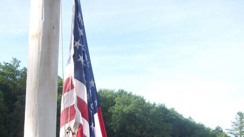 campers raising flag during flag ceremony 