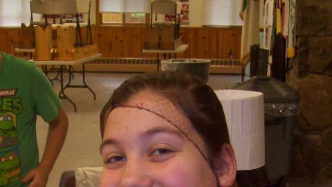 Youth holding up a burrito and smiling. 