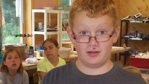 camper tie dying with two campers in the background