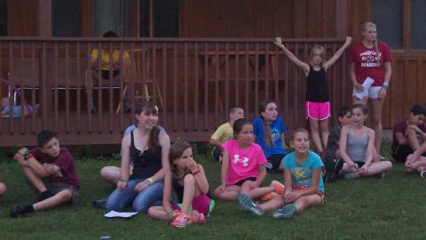 Youth sitting on the ground and watching something in the distance. 