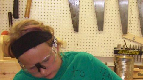 Camper works on a wood project in the camp wood shop. 