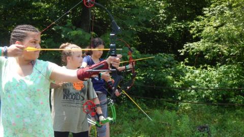 Youth shooting arrows as part of an archery program. 