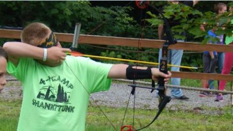 Camper prepares to shoot an arrow. 