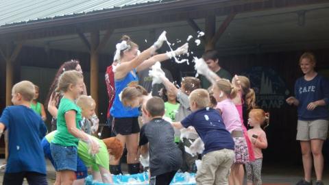 Youth playing with bubbles and splashing them at each other. 