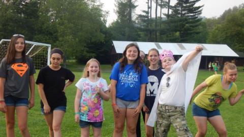 Youth pose for a photo. One youth sporting a cape. 