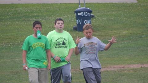 Youth walking across the field at camp. 