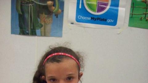 Camper poses with freshly baked loaf of bread. 