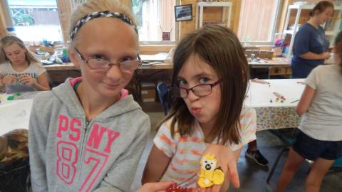 Two youth show off their crafts. 