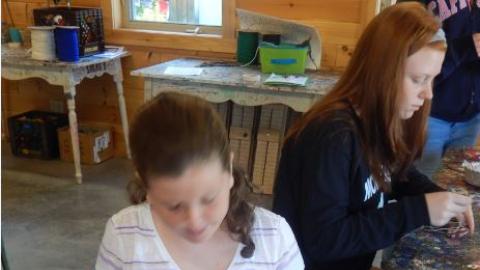 Campers work on dream catcher crafts. 